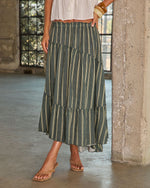 Forest green striped tiered maxi skirt with elastic waist, paired with white crop top and tan sandals