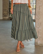 Forest green striped tiered maxi skirt with ruffled hem, elastic waist, styled with white crop top and tan sandals