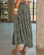 Tiered green striped maxi skirt with ruffled hem, elastic waist, styled with tan kitten heel sandals and stacked bangles