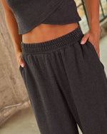 Charcoal gray wide-leg sweatpants with elastic waistband, paired with matching cropped top, hands in pockets