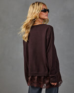 Women's oversized dark burgundy knit sweater with satin lace hem trim, styled with gray jeans and black sunglasses