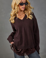 Women's oversized dark brown V-neck knit sweater with lace hem detail, styled with jeans and sunglasses