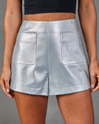 Silver metallic faux leather high-waist mini shorts with patch pockets, worn with black crop top