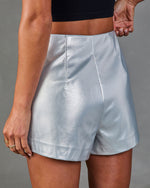 Silver metallic faux leather high-waist shorts on model with black crop top, side seam detail, mini length