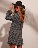 Black plaid smocked babydoll mini dress with long sleeves and open back, styled with black cowboy hat and aviator sunglasses