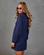 Woman modeling navy blue long-sleeve shirt dress with cat-eye sunglasses, wavy blonde hair, studio background