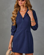 Navy blue mini shirt dress with V-neck collar, 3/4 roll-tab sleeves, front pockets, styled with gold bangles and woven clutch