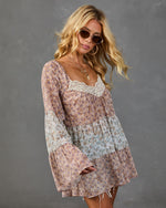 Boho floral mini dress with lace trim, bell sleeves, tiered skirt in blush pink and blue, styled with gold hoop earrings