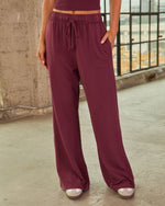 Burgundy wide-leg drawstring pants with elastic waistband and side pockets, styled with matching crop top and nude sandals
