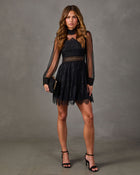 Black lace mini dress with sheer bishop sleeves, high neck and cutout waist, styled with black heels and a clutch