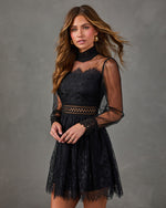 Black lace mini dress with sheer long sleeves, high smocked neckline, cutout waist and scalloped eyelash lace hem