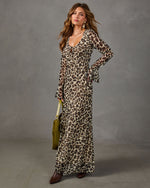 Leopard print chiffon maxi dress with flared long sleeves, styled with brown ankle boots and an olive green suede bag