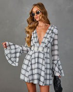 Gray plaid mini dress with deep V-neck and bell sleeves, styled with sunglasses and black clutch bag