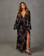 Black velvet floral maxi dress with plunging V-neck, bell sleeves, front knot and thigh-high slit, styled with black heels