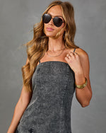Woman wearing charcoal acid-wash denim cami dress, aviator sunglasses, gold bangles, layered necklaces, and stacked rings