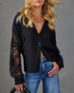 Black lace sleeve button-down blouse paired with blue jeans, featuring floral crochet detail on sheer sleeves
