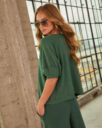Woman modeling forest green waffle-knit cropped sweatshirt and matching wide-leg pants with aviator sunglasses