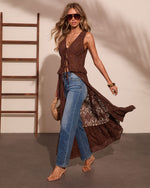 Woman wearing brown lace maxi duster top over blue straight-leg jeans with strappy heels and gold accessories