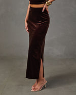 Chocolate brown velvet maxi skirt with side slit, styled with a matching crop top, gold bangles and clear heeled sandals