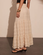 Cream lace tiered maxi skirt with smocked waist, styled with black crop top, kitten heels, and gold cuff bracelet