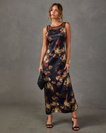 Black satin floral maxi dress with sheer mesh neckline, styled with gold cuff bracelets, black heels and woven clutch
