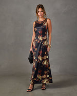 Black satin floral maxi dress with sheer mesh neckline, styled with gold cuff bracelets, black heels and woven clutch
