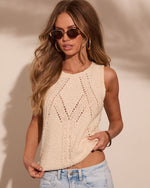 Cream crochet knit tank top styled with light wash jeans, gold hoop earrings, and tinted oval sunglasses on a model