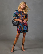Multicolor sequin floral mini dress with short sleeves, styled with black strappy heels and woven leather hobo bag
