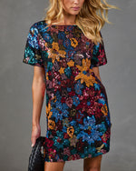 Multicolor sequin floral mini dress with short sleeves on blonde model, black background, festive party style