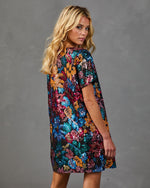 Woman modeling multicolor sequin floral mini dress with short sleeves, black base, T-shirt silhouette, back view