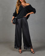 Black lace-trim knit sweater and satin wide-leg pants set with heels and woven clutch, women's elegant all-black outfit