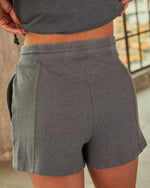 Charcoal gray women's sweat shorts with elastic waistband and side pockets, casual athleisure style