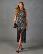 Black lace midi dress with front slit, nude lining, scalloped neckline, styled with black strappy heels and woven clutch