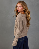 Woman modeling ribbed knit cropped sweater in taupe with long sleeves, paired with dark wash wide-leg jeans
