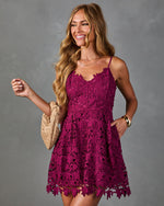 Magenta floral lace mini dress with spaghetti straps, A-line silhouette, modeled with woven clutch bag