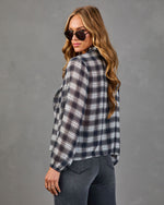 Woman modeling gray plaid long-sleeve blouse with balloon sleeves, paired with dark jeans and aviator sunglasses
