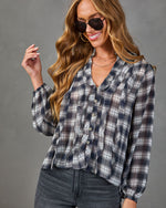 Women's plaid ruffle button-down blouse in navy and gray, styled with dark jeans and aviator sunglasses