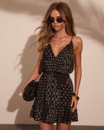 Black boho mini dress with geometric floral print, spaghetti straps, ruffle hem, styled with gold jewelry and sunglasses