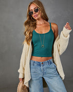 Woman wearing teal ribbed crop tank top, cream knit cardigan, light wash baggy jeans, gold necklace, and sunglasses