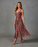 Floral ruched midi dress in red and sage green worn by woman with gold accessories and clear heels