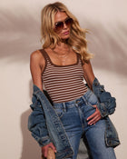 Woman wearing brown striped tank bodysuit, denim jacket off shoulders, high-waist jeans, aviator sunglasses, layered gold necklaces