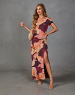 Burgundy floral maxi dress with off-shoulder neckline, side slit, ruched waist, styled with nude heels and woven clutch