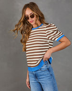 Marcine Striped Puff Sleeve Top with ribbed knit fabric, puff sleeves, and contrasting trims, paired with jeans and gold accessories, showcased by a young woman.