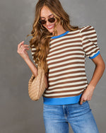 Model in Marcine Striped Puff Sleeve Top with brown and off-white stripes, blue trims, and puffed shoulders, styled with light-wash jeans and gold accessories.