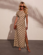 Woman wearing beige brown plaid midi dress with side slit, short sleeves, strappy heels, sunglasses, and tan clutch bag