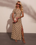 Woman wearing beige brown plaid maxi dress with flutter sleeves, side slit, strappy heels, and clutch bag