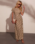 Woman wearing brown plaid maxi dress with short sleeves, styled with strappy heels, sunglasses, and tan clutch bag