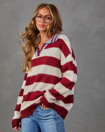 Woman wearing an oversized red and cream striped fuzzy knit sweater with blue polo collar, styled with light wash jeans
