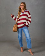 Woman in red and cream striped collared sweater with light blue trim, wide-leg jeans, clear heels and tan suede tote bag