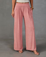 Women's dusty rose wide-leg pleated palazzo pants with elastic waistband, paired with nude strappy heels